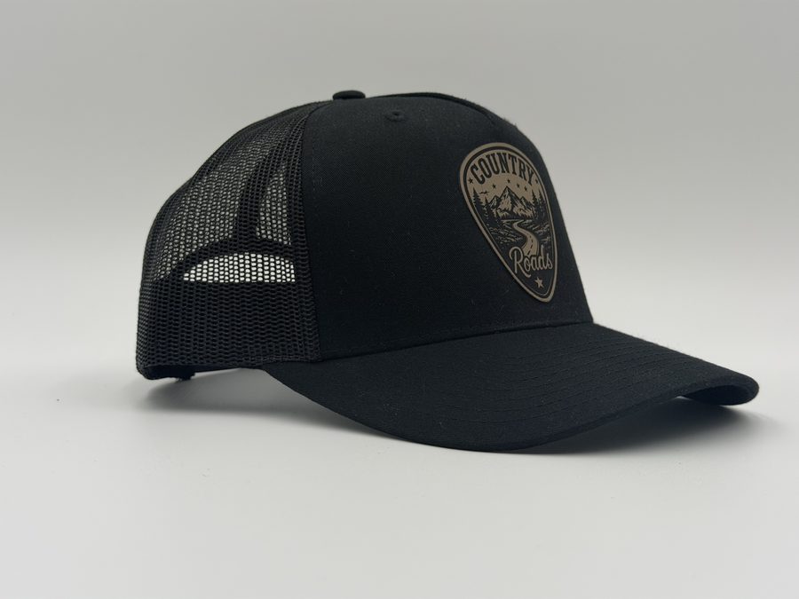Country Roads laser-engraved leather patch on a black mesh-back trucker cap