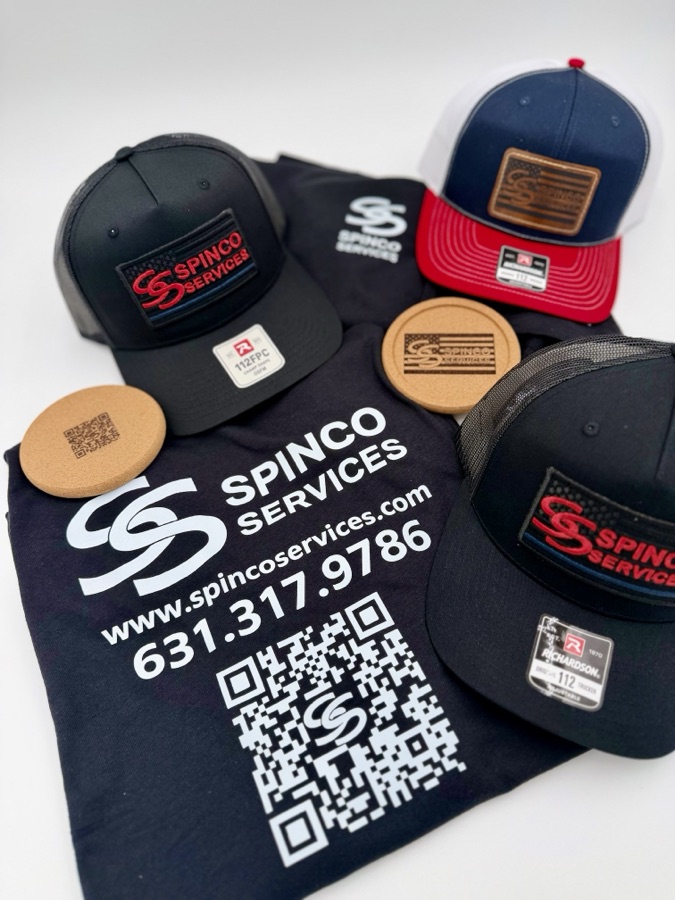 Spinco Services branding package — embroidered and laser-engraved leather patch trucker hats with laser-engraved cork coasters and a printed tee